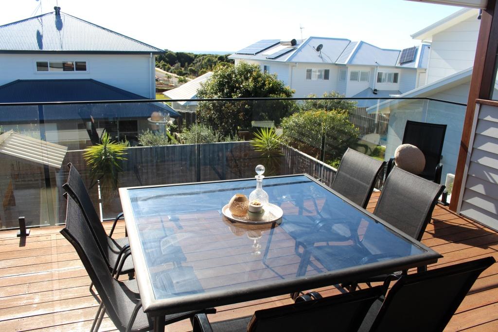 Large deck overlooking heated pool with four seater table at Waterside Escape