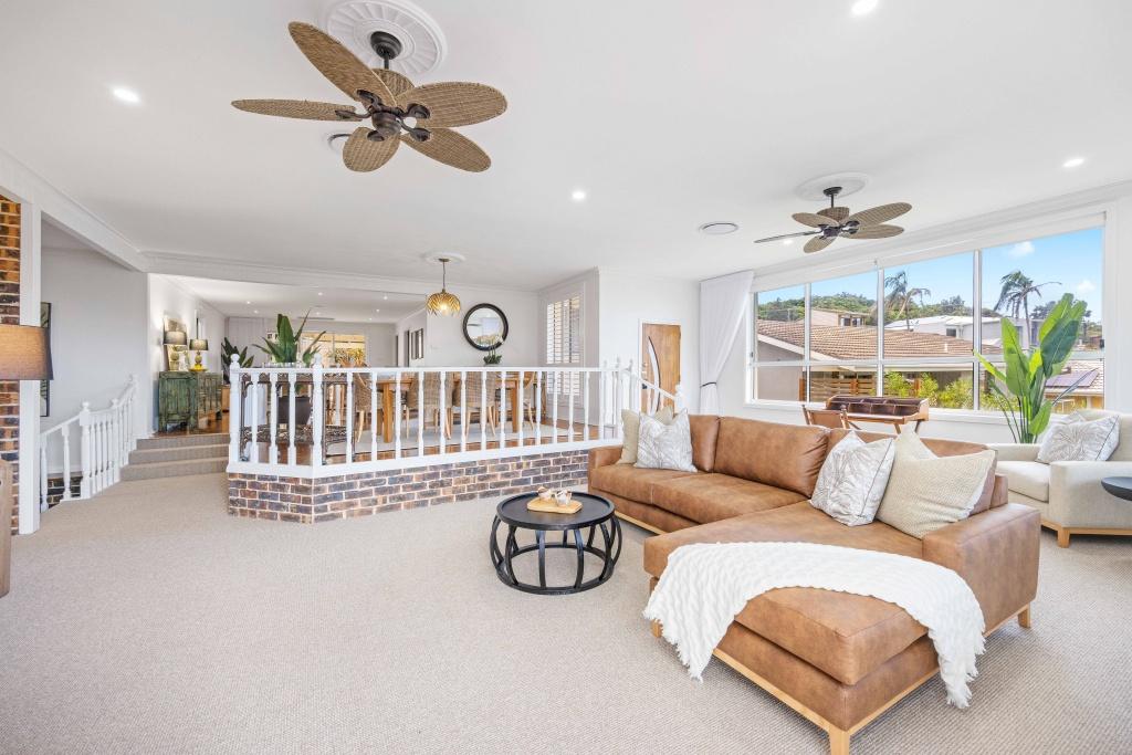 Lounge room with ceiling fan water views couch and arm chair at Beached at Lighthouse Port Macquarie