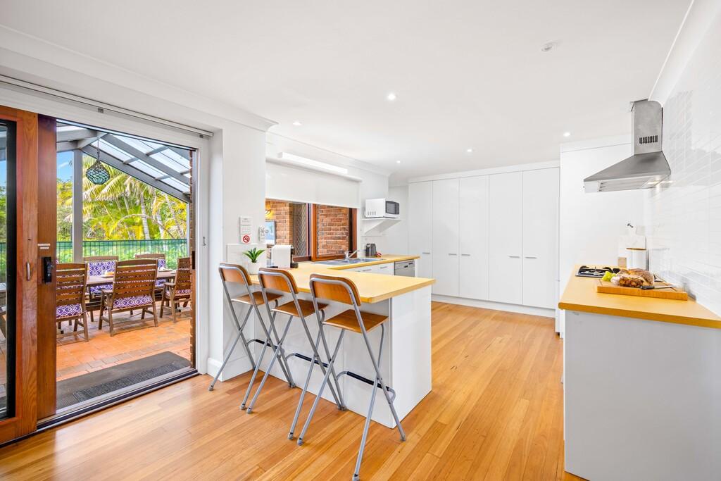 Full kitchen overlooking outdoor dining and swimming pool. Illalangi